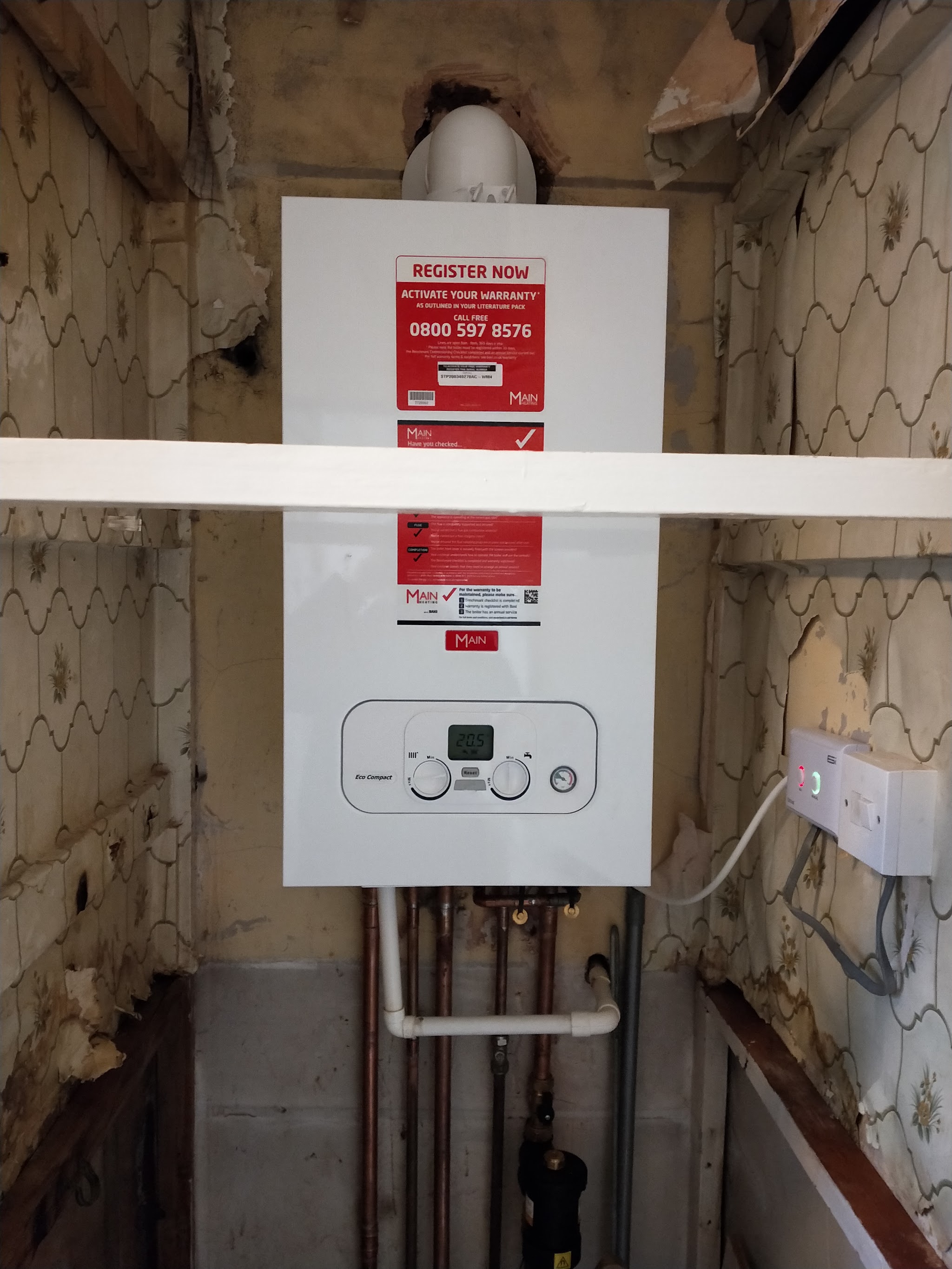 New boiler fitted in a stripped-back cupboard with fresh pipework below