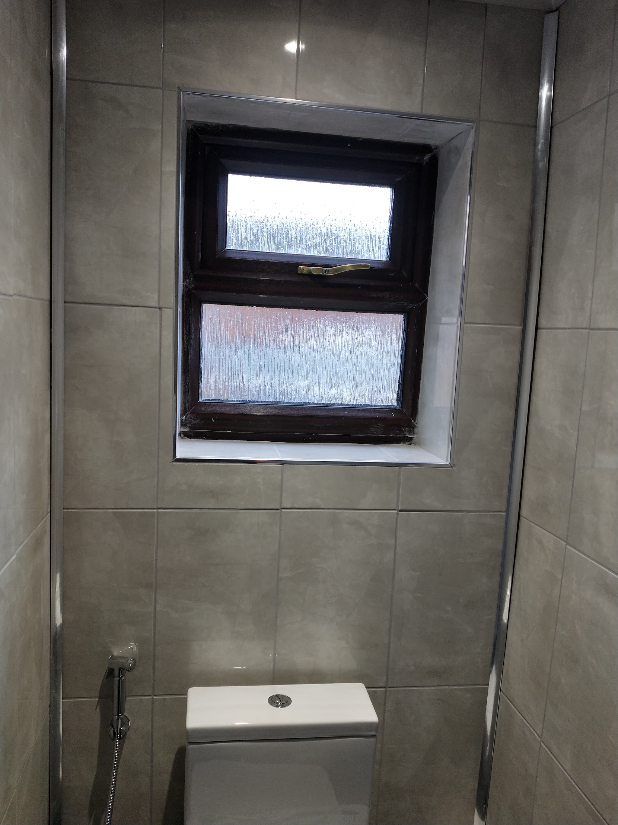 Tiled bathroom with window recess and new toilet